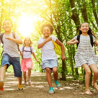Kinder rennen fröhlich lachend durch den Wald
