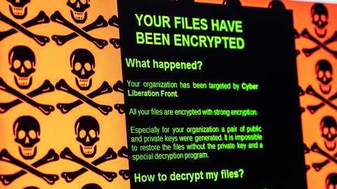 Computerbildschirm mit Erpresserbotschaft und Totenköpfen: Your files have been encrypted. – Ransomware, auch Erpressungssoftware, Kryptotrojaner oder Verschlüsselungstrojaner genannt, sind Schadprogramme. Sie ermöglichen Eindringlingen den Zugriff und die Manipulation von Daten oder des ganzen Computersystems und können bei Unternehmen schwere Schäden anrichten. "Ransom" ist das englische Wort für "Lösegeld".