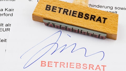 Stempel und Unterschrift "Betriebsrat" auf einem Schriftstück. Betriebsräte haben in Deutschland eine lange Tradition. Im Gesetz verankert, sollen sie die demokratische Kultur am Arbeitsplatz fördern und darauf achten, dass die Rechte der Beschäftigten geschützt werden. Werden sie heute noch gebraucht?