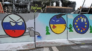 Ukraine-Smiley hält EU-Smiley an der Hand und streckt Russland-Smiley die Zunge heraus: Barrikade auf dem Kiewer Unabhängigkeitsplatz am 7. Dezember 2013 mit Zeichnungen, die den Beitritt der Ukraine zu Europa auf Kosten Russlands und seiner Gasdiplomatie darstellen