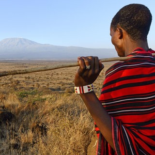 Massai mit Mount Kilimanjaro und Mount Mawenzi (in Tansania) links im Hintergrund