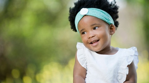 Schüchternes kleines Mädchen lächelt verlegen: Schüchterne Kinder können sich oft besser in andere hineinversetzen. Ein Defizit ist dieser Charakterzug nicht. Aber in der Schule haben sie es schwerer. Was hilft, sich zu trauen?