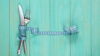 Besteck, umwickelt von einem Maßband (Symbolbild): “Bloß kein Gramm zu viel“: Lange dachte man, Ursache und Therapie von Magersucht liegen in der Familie. Doch neben der Psyche spielen auch Stoffwechsel und Genetik eine Rolle.