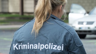 Rücken einer Frau. Sie trägt eine Jacke mit der Aufschrift: Kriminalpolizei. Bis heute gibt es bei der Kripo deutlich weniger Kolleginnen als Kollegen. Auch, weil ermittelnde Polizistinnen lange mit dem Vorurteil zu kämpfen hatten, Frau-Sein und Staatsgewalt passten nicht zusammen.