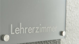 Schild mit Aufschrift "Lehrerzimmer": Immer wieder geraten Lehrer*innen in den Fokus, weil sie sich durch politisch rechte Taten und Aussagen hervortun