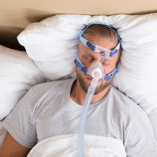 Mann mit Schlafapnoe und CPAP-Gerät: Menschen mit regelmäßigen Atemaussetzern sind häufig abgeschlagen und unkonzentriert