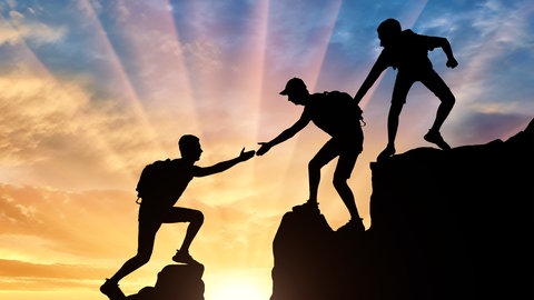 Bergsteiger überwindet eine Felsspalte mithilfe eines Kameraden (Grafik): Vertrauen ist beim Bergsteigen wichtig: Wir vertrauen Freunden, der Familie, ärztlichen Diagnosen und Parteien. Aber Vertrauen kann enttäuscht werden. Wie lernen wir skeptisch zu sein, ohne Vertrauen zu verlieren?