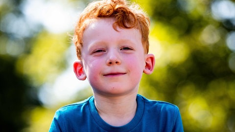 Rothaariger Junge: Dumme Sprüche gehören für Rothaarige immer noch zum Alltag, auch wenn sie heute nicht mehr Göttern geopfert, als Hexen denunziert oder antisemitisch verfolgt werden.