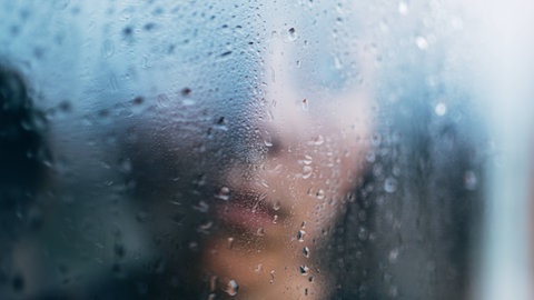 Junge verschwommen hinter einer regennassen Fensterscheibe: Kinder, die sexuelle Gewalt in der Familie erleben, sind ihr oft schutzlos ausgeliefert. Umso wichtiger ist, dass das Umfeld genau hinschaut und mutig handelt.IMAGO  Addictive Stock