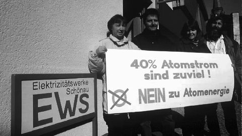 Mitglieder der Bürgerinitiative "Netzkauf" des Schwarzwaldstädtchens Schönau im März 1996 mit einem Transparent vor dem Büro und dem Logo der von ihr ins Leben gerufenen Elektrizitätswerke Schönau (EWS)