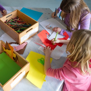Kinder basteln in der Ganztagsbetreuung: Ab dem Schuljahr 202627 gilt der Rechtsanspruch auf ein Ganztagsangebot für Grundschulkinder. Das soll Eltern entlasten, die auf Betreuung am Nachmittag angewiesen sind. 