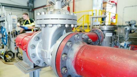 Ein Mitarbeiter steht hinter Rohren an einer Lithium-Pilotanlage der Natürlich Insheim GmbH; die gehört seit 1. Januar 2022 zur Vulcan Energie Ressourcen GmbH mit Sitz in Karlsruhe