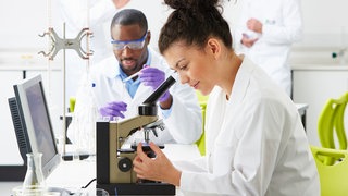 Nachwuchswissenschaflter im Labor: Wer kein Prof ist, hat in der Wissenschaft eine unsichere Zukunft. Doch es geht anders: mit Departments statt Lehrstühlen oder unbefristeten Stellen als Researcher und Lecturer.