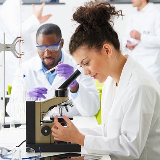 Nachwuchswissenschaflter im Labor: Wer kein Prof ist, hat in der Wissenschaft eine unsichere Zukunft. Doch es geht anders: mit Departments statt Lehrstühlen oder unbefristeten Stellen als Researcher und Lecturer.