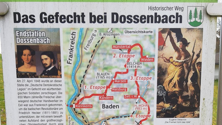 Badische Revolution 1848: Tafeln informieren über die "Deutsche Demokratische Legion", die am 27. April 1848  in Dossenbach geschlagen wird. Es war wohl eine eher armselige Unternehmung, kaum mehr als 800 bis 1.000 Mann meist linke Handwerker und Arbeiter. Anführer ist der Dichter Georg Herwegh. Er hat seine Frau Emma als Kundschafterin vorgeschickt, um mit Hecker Kontakt aufzunehmen. Aber es gelingt nicht, sich mit dessen Truppen zu vereinigen. 30 Männer sterben; 300 werden zu Gefangenen. Georg und Emma Herwegh fliehen.