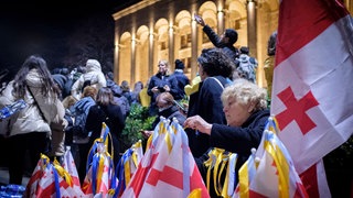 In Tiflis  Georgien verkauft eine Frau bei der Demonstration am 28. Februar 2022 gegen die russische Invasion in der Ukraine georgische Flaggen, die mit Bändern in den Farben der ukrainischen Flagge geschmückt sind. Seit 2008 besetzt Russland Teile Georgiens. Im Frühjahr 2023 demonstrierten die Georgier gegen ihre prorussische Regierung. Der russische Angriffskrieg gegen die Ukraine entscheidet auch über ihre Zukunft.