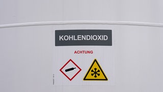"Kohlendioxid" steht auf einem Tank der neuen Power-to-Liquid-Demonstrationsanlage auf dem Gelände der Raffinerie H&R Ölwerke Schindler GmbH im Hafen. Mit der Anlage sollen aus natürlichen Wasserstoffen und Kohlenstoffdioxid (CO2) nachhaltige Treibstoffe für den Straßen- und Luftverkehr, sogenannte E-Fuels, hergestellt werden.