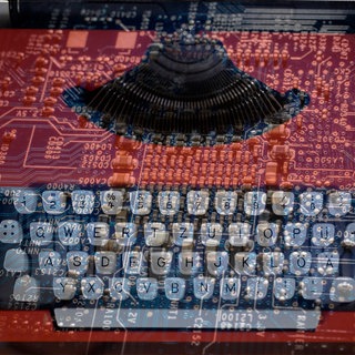 Alte Schreibmaschine und die Platine eines Computers in einer Doppelbelichtung: Künstliche Intelligenz kann Texte sowie Körper, Bewegung und Stimme imitieren.  Kulturschaffende aus Literatur und Film fühlen sich enteignet und protestieren.