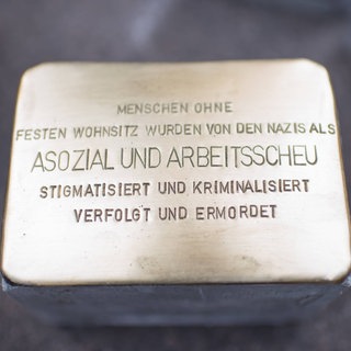Stolperstein mit der Aufschrift: "Menschen ohne festen Wohnsitz wurden von den Nazis als "asozial und arbeitsscheu" stigmatisiert und kriminalisiert, verfolgt und ermordet": Mit den "Stolpersteinen" des Kölner Bildhauers Gunter Demnig wird seit 2016 auf dem Berliner Alexanderplatz der Menschen gedacht, die im Nationalsozialismus als "asozial" verfolgt und ermordet wurden