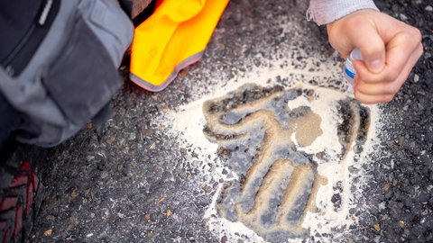Der Handabdruck eines Aktivisten klebt auf der Straße, als Klimaaktivisten von der «Extinction Rebellion Austria» und «Letzte Generation Deutschland» gemeinsam gegen das geplante Tunnelstraßenprojekt «Tunnelspinne  Schnellstraße S18» protestieren.