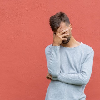 Junger Mann hält sich beschämt die Hand vor den gesenkten Kopf: Psychologinnen und Soziologen sagen, dass die Scham unsere Privatsphäre schützt, zwischenmenschliche Kommunikation regelt und soziale Gruppen stabilisiert. Wer sich schämt, weiß, dass er oder sie sich gegenüber einer anderen Person falsch verhalten hat. Individuelle Schamgrenzen zeigen, wenn uns jemand oder etwas zu nah kommt.