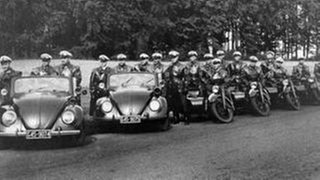 Historische Aufnahme von Polizisten mit Autos und Motorrollern