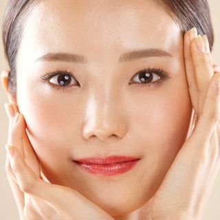 Gesicht einer hübschen jungen asiatischen Frau: Attraktive Menschen scheinen es im Leben leichter zu haben. Studien weisen darauf hin, dass sie eher positive Aufmerksamkeit bekommen und mehr Karrierechancen im Beruf haben. 