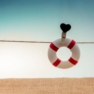 An einer Schnur befestigter Rettungsring mit schwarzem Herzsymbol: Mehr als 9.000 Menschen nehmen sich jedes Jahr in Deutschland das Leben. Forscherinnen und Forscher haben wirksame Therapien, Apps und Beratungskonzepte für Betroffene und Angehörige mit Suizidgedanken entwickelt. Allerdings fehlt Geld, um die Hilfsangebote überall verfügbar zu machen. 