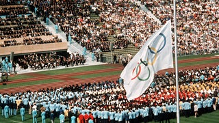Trauerfeier am 6.9.1972 im Münchner Olympiastadion für die Opfer des Terror-Anschlages bei den Olympischen Sommerspielen. Die weiße Olympia-Flagge mit den fünf bunten Ringen hängt auf Halbmast.