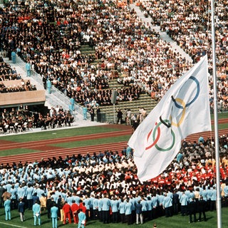Trauerfeier am 6.9.1972 im Münchner Olympiastadion für die Opfer des Terror-Anschlages bei den Olympischen Sommerspielen. Die weiße Olympia-Flagge mit den fünf bunten Ringen hängt auf Halbmast.