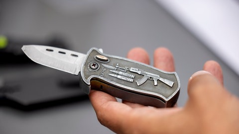Ein Polizeibeamter hält ein sichergestelltes, verbotenes Springmesser in der Hand: Tödliche Messerangriffe nehmen zu und beschäftigen die Polizei nicht erst seit den Ereignissen von Solingen. Hier war das Motiv Terrorismus. Das ist aber die Ausnahme bei der Messergewalt. 