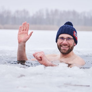 Eisbader Mario geht bei Minusgraden mit Mütze ins Wasser. Mario hatte sich mit dem Beil ein Loch in die circa 10 cm dicke Eisdecke geschlagen und geht nun drei mal hintereinander für kurze Zeit in den Habermannsee: Dass Kälte gut für den Körper sein kann, wusste schon Sebastian Kneipp. Mittlerweile gibt es viele Menschen, die auch im Winter in Seen und Meeren schwimmen. Sportler schätzen ein Eisbad, um Muskelschäden schneller heilen zu lassen. Kältetherapien sollen die Schmerzen bei Rheuma oder Migräne lindern. 