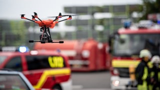 Eine Drohne fliegt vor Einsatzfahrzeugen bei einem Test-Einsatz. Das Deutsche Rettungsrobotik-Zentrum (DRZ) stellt einen neuartigen Robotikleitwagen für Katastropheneinsätze vor. Bei Notfällen sind Einsatzkräfte mit gefährlichen Situationen konfrontiert, Robotersysteme sollen sie unterstützen. 