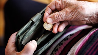 Eine ältere Dame zählt Geldmünzen aus ihrem Portemonnaie ab: Experten sagen, dass die Rentenkatastrophe droht. Das System muss dringend reformiert werden und Beschäftigte müssen stärker als bisher selbst fürs Alter vorsorgen. 