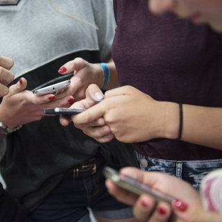 Jugendliche tippen auf ihren Handys