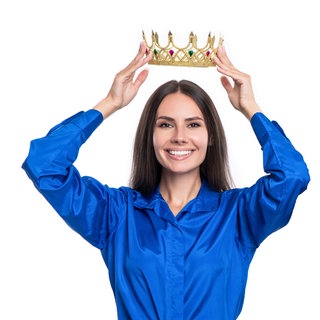 Eine Frau in Business-Kleidung setzt sich selbst lächelnd eine Krone auf: Ein starkes Ego und Dominanz, Streben nach Macht und Bewunderung galten lange als Voraussetzungen, um als Führungskraft in Unternehmen Karriere zu machen. Tatsächlich zeigen Studien, dass zumindest weibliche narzisstische CEOs die Unternehmensleistung steigern. 