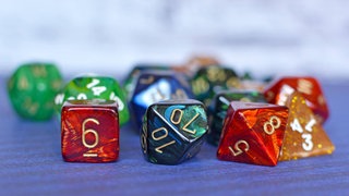 Tisch mit anderen Würfeln in verschwommenen Hintergrund.