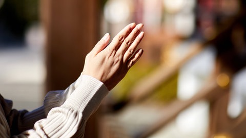 Eine Frau klatscht in die Hände.