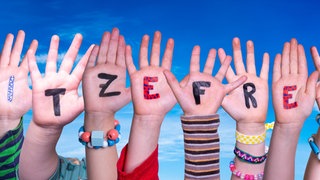 Kinderhände mit der Aufschrift "Hitzefrei".