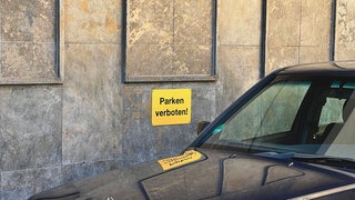 Parken verboten Schil, vor dem ein Auto parkt. Um die Kontrolle der Falschparker effizienter zu gestalten wird jetzt an der Uni Hohenheim ein Scan-Fahrzeug getestet, das nicht 50 Autos pro Stunde kontrollieren kann, wie Mitarbeiter des Ordnungsamtes, sondern bei einer Fahrgeschwindigkeit von bis zu 80 kmh 1000 geparkte Fahrzeuge überprüft.