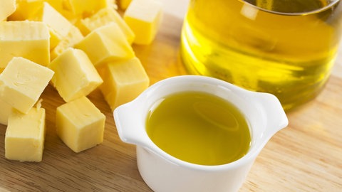 Butterwürfel und eine Flasche mit Olivenöl: Ob Stoffe fest, flüssig oder gasförmig sind, hängt davon ab, wie stark die einzelnen Moleküle sich gegenseitig anziehen – welche Kräfte also zwischen ihnen wirken. 