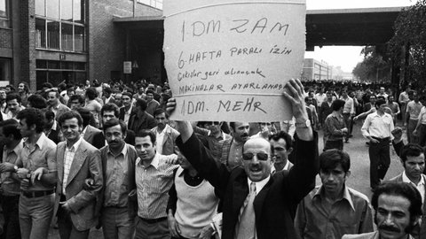 Der Streik bei den Ford-Werken, hier am 27. bis 29. 8. 1973 in Köln, war ein Spontanstreik, also ein wilder Streik. Die Serie von Streiks wurde u. von türkischen Migranten organisiert. Ursache war u. a. die starke Inflation. Auf dem Schild in türkischer Sprache, das einer der Männer in die Höhe hält, steht in der letzten Zeile auf Deutsch "1 DM mehr".