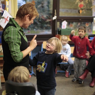 Lehrerin und Kind mit Down-Syndrom im Unterricht