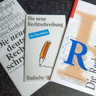 Drei Broschüren zur neuen deutschen Rechtschreibung liegen nebeneinander