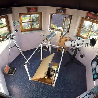 Eine Astronomiekuppel mit vielen Fenstern und mehreren Teleskopen