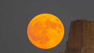 Störmond über einer Burg in Italien. Der Störmond ist der traditionelle Name für den Vollmond im August, besonders bekannt in Nordamerika. Auch auf dem Mond gibt es Jahreszeiten. Woran erkennt man die?