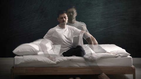 Schlafwandler richtet sich im Bett auf: Schlafwandeln gehört zu den Verhaltensweisen, die die Wissenschaft als “Parasomnien” zusammenfasst. Manche Menschen kochen, fahren Auto oder bedrängen andere sexuell. Was passiert da? Und was hilft Betroffenen?