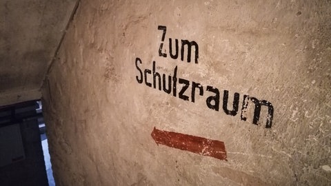 "Zum Schutzraum" steht an einer Wand im Keller eines Hauses iin Frankfurt. Durch den Angriffskrieg Russlands auf die Ukraine geraten solche Schutzräume auch in Deutschland wieder ins Bewusstsein der Bevölkerung.