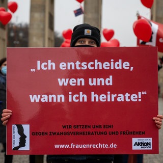 Eine Aktivistin steht vor dem Brandenburger Tor und hält ein Schild mit der Aufschrift "Ich entscheide, wen und wann ich heirate!". Terre des Femmes demonstriert mit der Aktion #meinherzgehörtmir gegen Zwangsverheiratungen und Frühehen. 