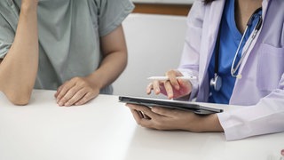 Symbolbild: Arzt beruhigt Patientin